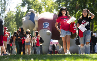 Fresno State students walk near large Bulldog inflatable on campus.