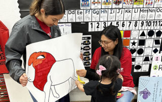 Preschool student works on art project with Fresno State student Neha Mann.