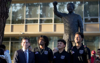 President Saul Jimenez and students in front of Mandela statue